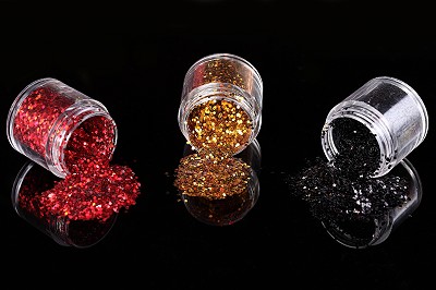 three attractive colored glitter bottles red gold and black on black background